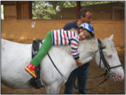 Kind auf Pferd im Kindercamp