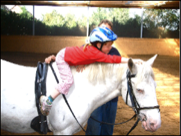 Kind auf einem Pferd im Kindercamp